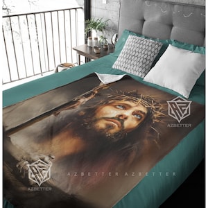 May include: A fleece blanket with a painting of Jesus Christ wearing a crown of thorns. The painting is in shades of brown, gray, and blue. The blanket has the text "AZBETTER" printed on it.
