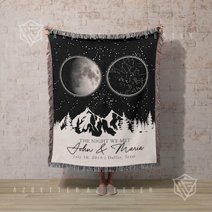 May include: A black and white woven throw blanket featuring a moon phase and star constellation graphic above a mountain range. The text reads THE NIGHT WE MET, John & Maria, July 10, 2019 | Dallas, Texas. The blanket has a fringed edge.