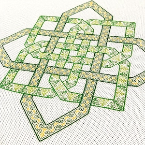 Puede incluir: Un patrón de punto de cruz de nudo celta verde y amarillo sobre tela Aida blanca.