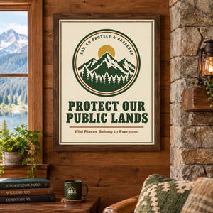 May include: A framed rectangular wall art print featuring a circular emblem with a green mountain range, a yellow sun, and a forest of pine trees. The text reads: EST. TO PROTECT & PRESERVE, PROTECT OUR PUBLIC LANDS, and Wild Places Belong to Everyone.