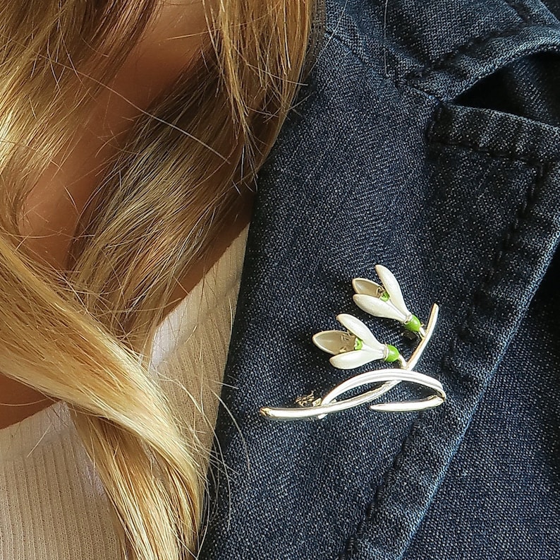 Snowdrop two white flowers brooch jewellery gift by ATLondonJewels, on a blue jacket lapel.