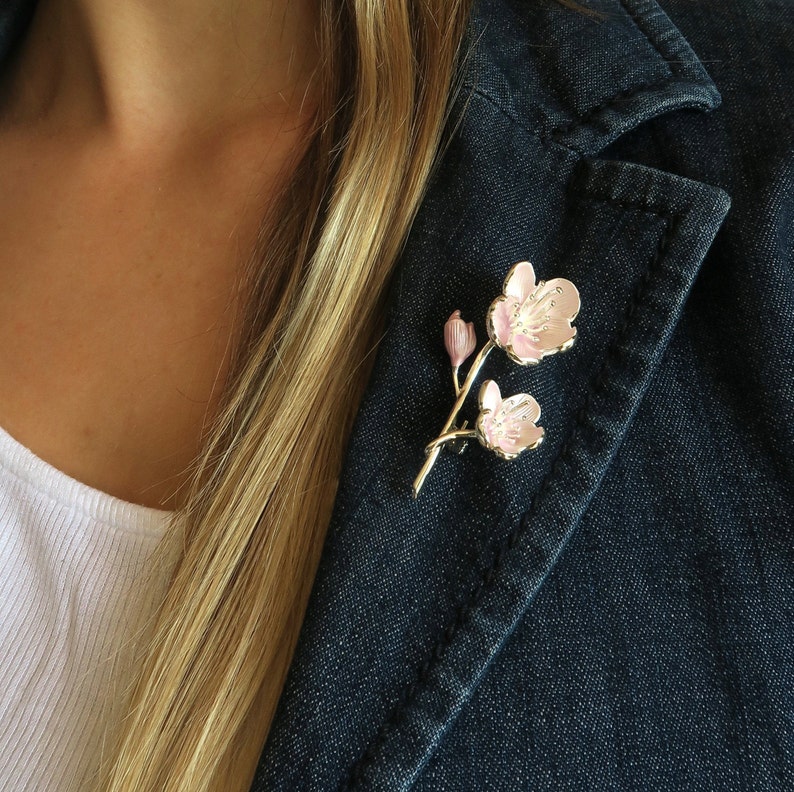 Cherry blossom pink flower brooch jewellery gift on a blue denim jacket lapel, by ATLondonJewels.