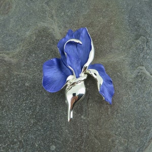 Iris blue flower brooch by ATLondonJewels, pictured on a state background.