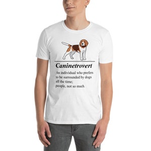 May include: White t-shirt featuring a cartoon beagle and the word "Caninetrovert." The text below defines a caninetrovert as someone who prefers dogs over people. The shirt is a casual wear item.