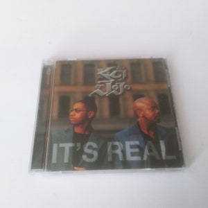 May include: A CD case with a photo of two men in front of a brick building. The album cover is titled "K-Ci & JoJo" and "It's Real".