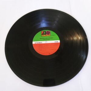 May include: Black vinyl record with a green, red, and white label. The label says "Atlantic" and "Emerson, Lake & Palmer Love Beach".