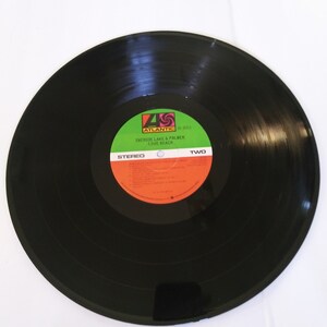 May include: Black vinyl record with a green, orange, and black label. The label reads "Atlantic" and "Emerson, Lake & Palmer Love Beach, Two, Stereo".