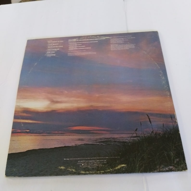 May include: Back cover of a vinyl record with a sunset over the ocean. The album title is "Portrait of an Anglo Gentleman" and the track list includes "Sweetheart is Too" and "Love Splash".