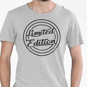 Könnte beinhalten: Ein graues T-Shirt mit einem schwarzen Kreis-Motiv, auf dem in einer Vintage-Schriftart "Limited Edition" steht.