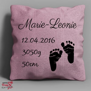 Könnte beinhalten: Ein staubrosa Kissen mit schwarzem Text und Fußabdrücken. Der Text lautet "Marie-Leonie", "12.04.2016", "3050g" und "50cm". Das Kissen zeigt zwei schwarze Fußabdrücke.