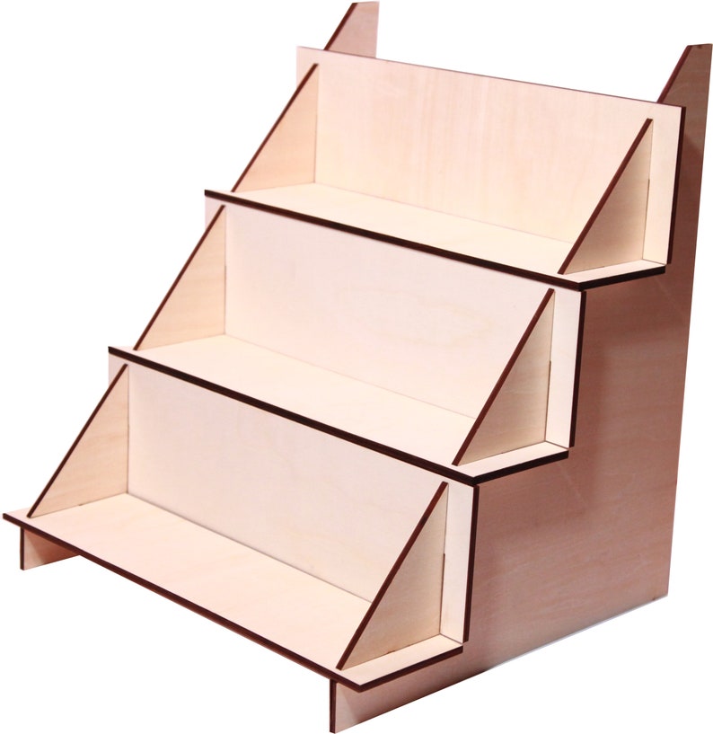 May include: A wooden display stand with four shelves. The stand is made of light wood with a natural finish. The shelves are angled to create a tiered effect.