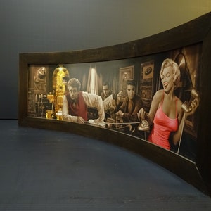 Può includere: Una stampa incorniciata di una scena vintage con quattro persone in un bar. La stampa presenta una donna con un vestito rosa sul lato destro dell'immagine e tre uomini sul lato sinistro dell'immagine. La donna è al telefono e gli uomini sono seduti al bancone del bar. La stampa è in una cornice di legno scuro.