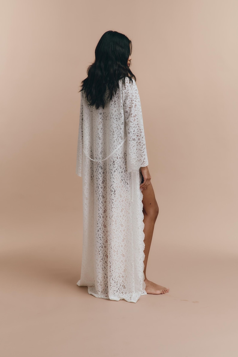 May include: A white lace robe with long sleeves and a flowing silhouette.