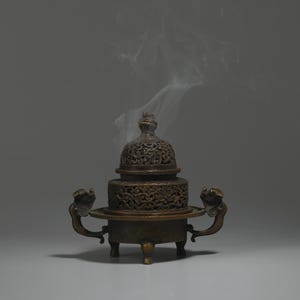 May include: A bronze incense burner with intricate carvings and a lid. Smoke rises from the burner, creating a wispy cloud.