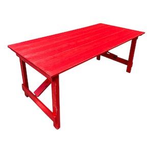 May include: A vibrant red wooden table with a rectangular top and angled legs. The table is painted a solid red colour. The table's dimensions are approximately 152 cm long and 76 cm wide.