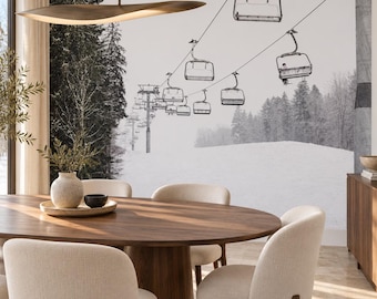 Puede incluir: Un comedor con una gran mesa ovalada de madera rodeada de cuatro sillas tapizadas de color crema. Un mural de pared muestra un paisaje nevado en blanco y negro con telesillas. Una lámpara colgante ancha y curva cuelga arriba.