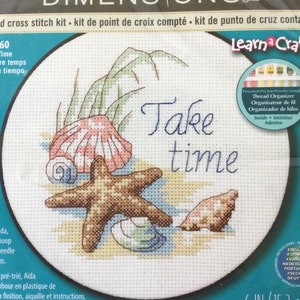 Può includere: Un kit di punto croce con una stella marina, conchiglie e il testo "Take time". Il kit include un telaio da 6 pollici (15,2 cm), tessuto Aida pre-ordinato, ago di plastica e istruzioni.