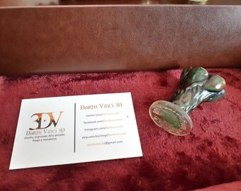 May include: A small, green and brown mottled wax seal stamp with a clear circular base, positioned next to a white business card featuring the text Darhi Vinci 3D, social media handles, and the email address darthvinci3d@gmail.com.