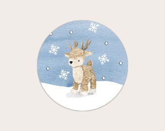 May include: A watercolor illustration of a reindeer standing in a snowy scene. The reindeer is brown with white accents and antlers. The background is a light blue with white snowflakes.