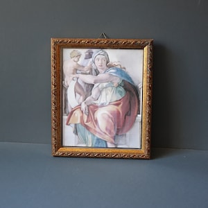 Può includere: Una stampa incorniciata di un dipinto che raffigura una donna con una veste rossa e blu, che tiene un rotolo, con un bambino in piedi accanto a lei.