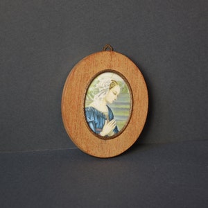 Oval icon of Madonna lippina. Vintage wooden wall in Tuscan Renaissance style