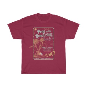 May include: A maroon t-shirt with a vintage-style illustration of a musical festival called "Prog on the Ranch 2020". The illustration features a tree, musical notes, and a group of people and animals. The text "April 3-4th, 2020, Gibson Jay Ranch, Brooksville, Florida" is included in the illustration. The text "Celebrating 5 Years of Friendship & Music" is also included in the illustration.