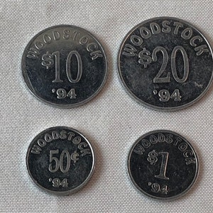May include: Four silver-colored tokens with the word "WOODSTOCK" and a dollar amount printed on them. The tokens are from 1994 and show the amounts $10, $20, $50, and $1.