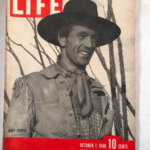 May include: Vintage LIFE magazine cover featuring Gary Cooper. The cover has a red banner at the top with the word "LIFE" in white. The cover also includes the date "OCTOBER 7, 1940" and the price "10 CENTS".