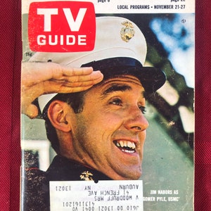 May include: A vintage TV Guide magazine cover featuring a smiling man in a USMC uniform saluting. The cover text reads "PRO FOOTBALL'S NEW BOSS - THE GHOST HUNT ON TV" and "TV GUIDE".