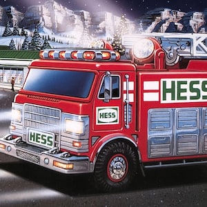 May include: A red Hess fire truck toy with a white ladder on top and a smaller red Hess rescue vehicle toy. Both vehicles feature the green and white Hess logo. The scene depicts a winter setting with a gas station in the background at night.