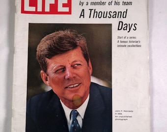 May include: A vintage issue of LIFE magazine from July 16, 1965, featuring a portrait of John F. Kennedy on the cover. The cover text includes "A Thousand Days" and the price of 35¢. The magazine is in good condition.