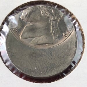 May include: A silver US quarter coin with the profile of George Washington on the obverse side. The coin is in a plastic coin holder.