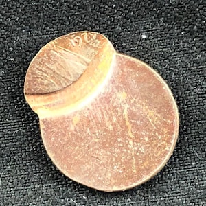 May include: A copper-colored 1971 US penny with a bent edge. The coin is worn and has a patina.