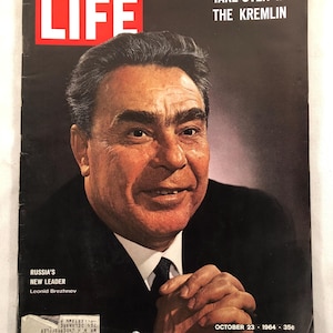 May include: A vintage LIFE magazine cover featuring a portrait of Leonid Brezhnev, identified as Russia's New Leader. The cover has the text "TAKE-OVER IN THE KREMLIN" and the date "OCTOBER 23 1964". The magazine has a red LIFE logo.