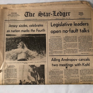 May include: A black and white newspaper clipping from The Star-Ledger, dated July 5, 1982. The headline reads "Jersey sizzles, celebrates as nation marks the Fourth". The sub-headline reads "Legislative leaders open no-fault talks".