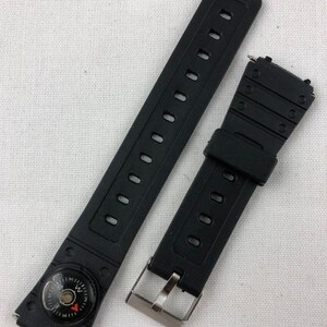 May include: Two black watch bands with a compass on one end. The band on the left has a compass with a red needle and a black face. The band on the right has a silver buckle.