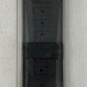 May include: Black watch strap in a clear plastic package. The strap is labeled "Sportstrap K-24 for Casio & Others 11/16" 18mm 395".