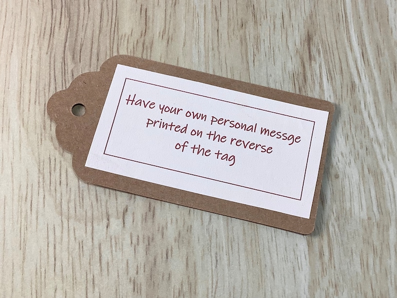 K&ouml;nnte beinhalten: Ein braunes Papier-Geschenk-Etikett mit einem wei&szlig;en Etikett. Das Etikett hat einen roten Rand und den Text "Have your own personal message printed on the reverse of the tag".