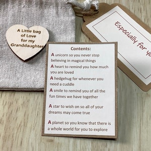 K&ouml;nnte beinhalten: Eine kleine braune Papiert&uuml;te mit einem Holzh&auml;uschen, auf dem "A Little bag of Love for my Granddaughter" steht. Die T&uuml;te ist offen und eine Karte mit dem Text "Especially for you" ist sichtbar. Die Karte enth&auml;lt eine Liste von Artikeln mit der &Uuml;berschrift "Contents:"  Die Liste umfasst: "A unicorn so you never stop believing in magical things", "A heart to remind you how much you are loved", "A hedgehog for whenever you need a cuddle", "A smile to remind you of all the fun times we have together", "A star to wish on so all of your dreams may come true", "A planet so you know that there is a whole world for you to explore".