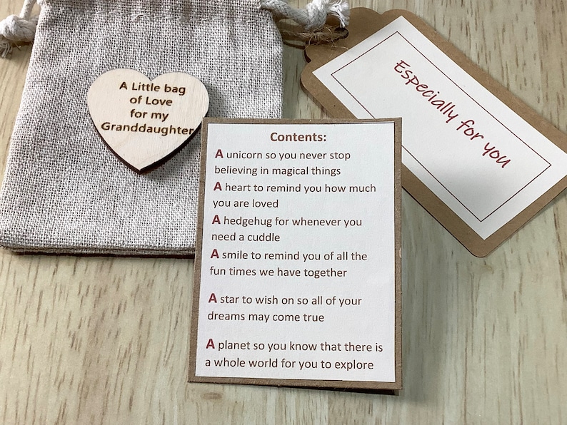K&ouml;nnte beinhalten: Eine kleine braune Papiert&uuml;te mit einem Holzh&auml;uschen, auf dem "A Little bag of Love for my Granddaughter" steht. Die T&uuml;te ist offen und eine Karte mit dem Text "Especially for you" ist sichtbar. Die Karte enth&auml;lt eine Liste von Artikeln mit der &Uuml;berschrift "Contents:"  Die Liste umfasst: "A unicorn so you never stop believing in magical things", "A heart to remind you how much you are loved", "A hedgehog for whenever you need a cuddle", "A smile to remind you of all the fun times we have together", "A star to wish on so all of your dreams may come true", "A planet so you know that there is a whole world for you to explore".