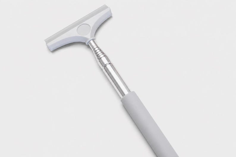 May include: A squeegee featuring a white T-shaped head with a flexible blade, a silver-colored telescopic metal handle with multiple segments, and a solid light gray cylindrical grip at the base of the handle for manual operation.