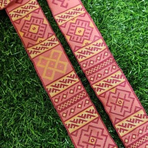 May include: Two red and gold patterned fabric ribbon trims with geometric designs.
