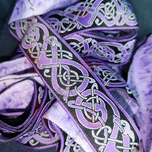 May include: Purple and black woven trim with a Celtic knot design. The trim is made of a soft, durable fabric and is perfect for adding a touch of style to any project.