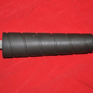 Op de afbeelding: Een zwart en zilveren gereedschap met een spiraalvormige handgreep en een metalen punt. Het gereedschap is ongeveer 30 cm lang.