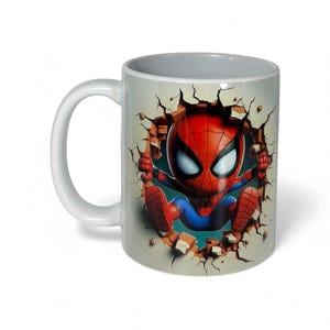 May include: White ceramic mug featuring a cartoon Spider-Man character breaking through a wall. The design shows Spider-Man in his classic red and blue suit, with a detailed cracked wall effect.