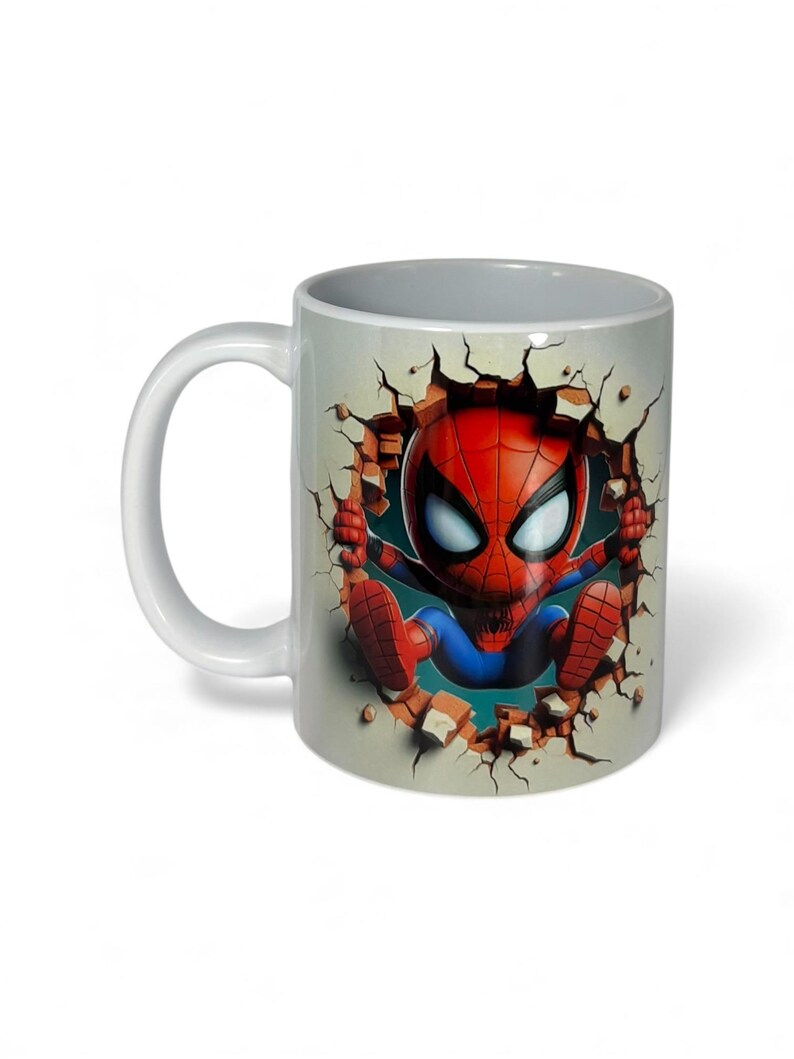May include: White ceramic mug featuring a cartoon Spider-Man character breaking through a wall. The design shows Spider-Man in his classic red and blue suit, with a detailed cracked wall effect.