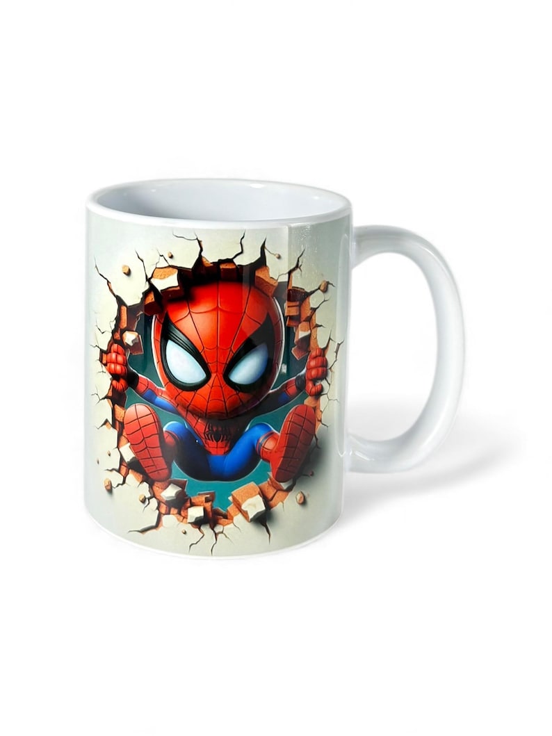 May include: White ceramic mug featuring a cartoon Spider-Man character breaking through a wall. The superhero is depicted in his classic red and blue suit, with a detailed mask. The mug has a curved handle and a glossy finish.