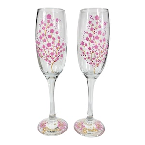 Duo of Cherry Blossom wedding champagne flutes in light pink with metallic gold stem. Personalised with name and date.
