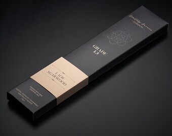 Può includere: Una scatola nera con lettere dorate che recitano "Waldly Frana - LONDON" e "GRADE 1.3". Un'etichetta beige più piccola sulla scatola recita "LAOS AGARWOOD" e "CREATED WITH RARE ESSENTIAL OILS. NATURAL AUTHENTIC | SUSTAINABLE HAND ROLLED INCENSE 100g".