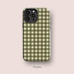 May include: A rectangular smartphone case featuring a repeating olive green and cream white gingham check pattern. The case has a black camera module cutout in the upper left corner with three circular lenses and a flash. The text Acaso. is visible.